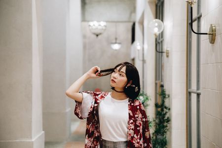 portrait of asian girl with white shirt and skirt looking in outdoor urban vintage film styleの写真素材