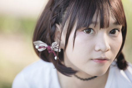 portrait of asian girl with white shirt and skirt looking in outdoor nature vintage film styleの写真素材