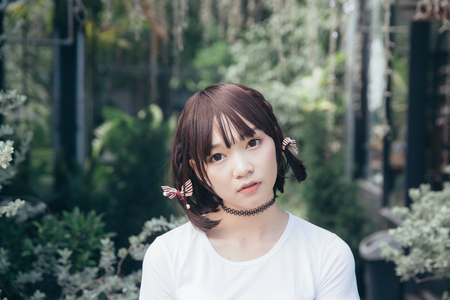 portrait of asian girl with white shirt and skirt looking in outdoor nature vintage film styleの写真素材