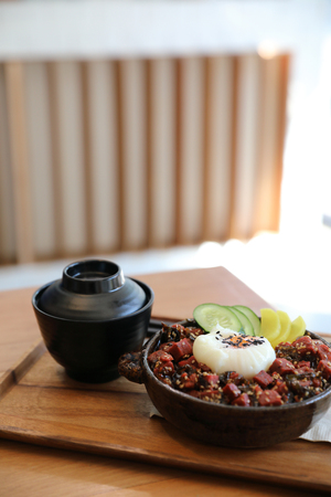 Steak tuna on rice with egg Japanese style on wooden tableの写真素材