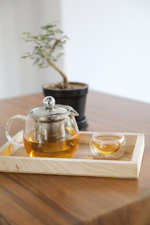 Hot teacup with teapot beverage on wooden tableの写真素材