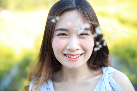 Portrait of Young Asian woman girl smile in flower gardenの写真素材