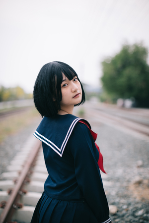 Portrait of asian japanese school girl costume looking at railway park outdoor film vintage styleの写真素材