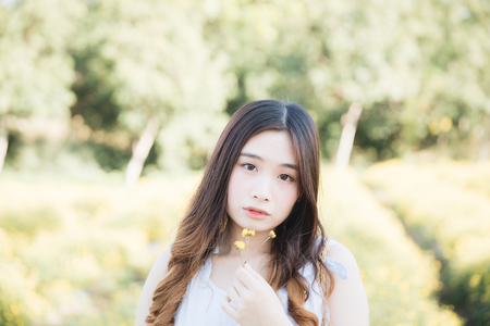 Portrait of Young Asian woman girl smile in flower gardenの写真素材
