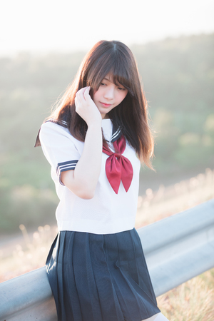 Portrait of Japanese school girl uniform smile with walkway and riverの写真素材