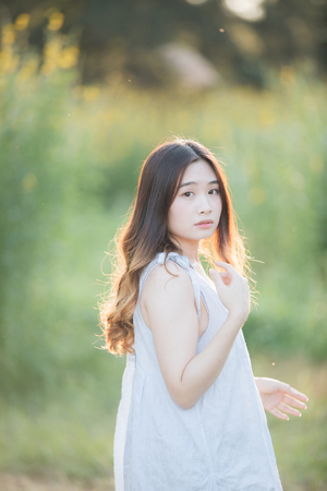 Portrait of Young Asian woman girl smile in flower gardenの写真素材