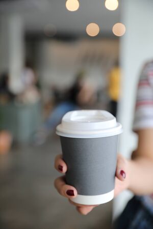 take home hot cappuccino or Latte art coffee made from milk with female handの写真素材