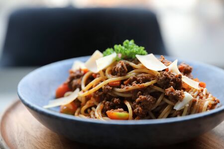 spaghetti Bolognese with minced beef and tomato sauce garnished with parmesan cheese and basil, Italian foodの写真素材
