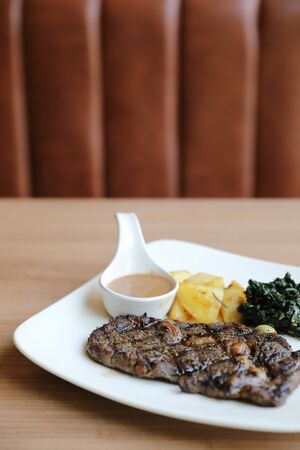 beef steak with potato on wood backgroundの写真素材