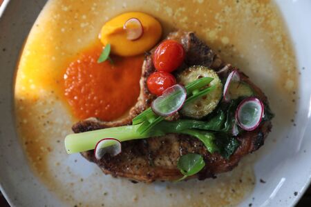 Grilled Porkchop and vegetables on top on wood backgroundの写真素材