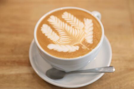 cappuccino or Latte art coffee made from milk on the wood table in coffee shop