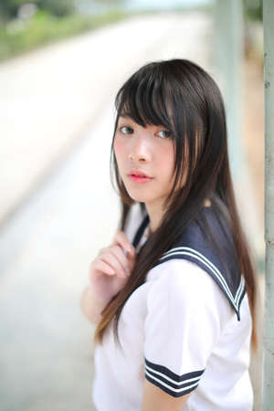 Asian school girl sitting with outdoor backgroundの写真素材