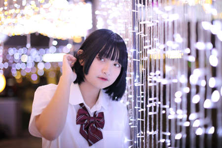 Portrait of asian japanese school girl costume looking in urban night with bokehの写真素材