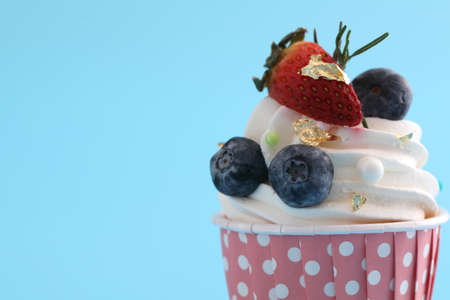 Colorful cupcake isolated in blue backgroundの写真素材