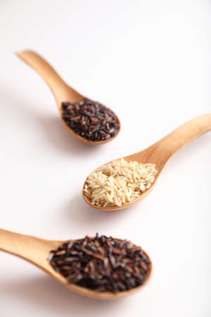 Organic raw brown rice and riceberry rice on spoon in close upの写真素材