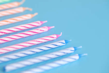 Colorful candles isolated in blue backgroundの写真素材