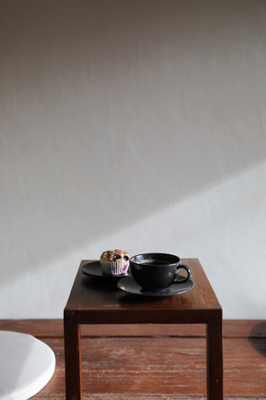 Coffee cup with muffin on wood table in local coffee shopの写真素材