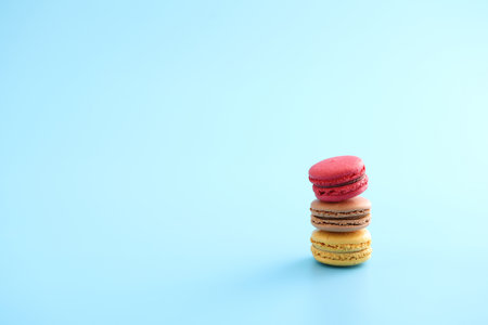 Colorful macarons isolated in blue backgroundの写真素材
