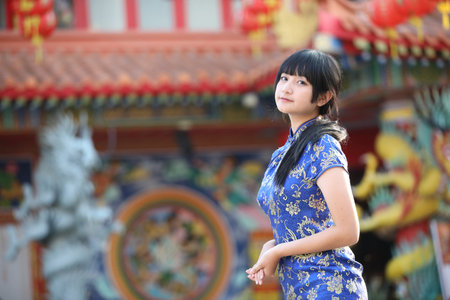beauty woman wear red cheongsam looking and smile in chinese new yearの写真素材