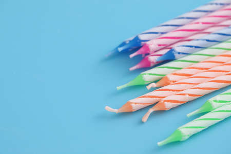 Colorful candles isolated in blue backgroundの写真素材