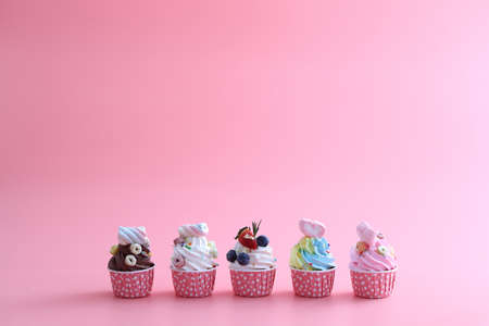 Colorful cupcakes isolated in pink backgroundの写真素材