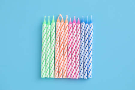 Colorful candles isolated in blue backgroundの写真素材