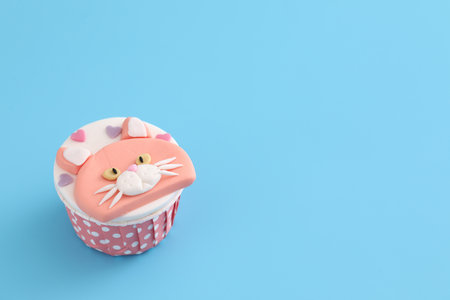 Cute cat cupcake isolated in blue backgroundの写真素材
