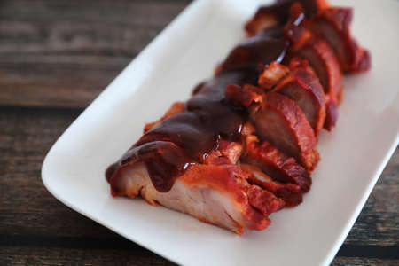 Roasted pork thai local food with red sauce on wood backgroundの写真素材