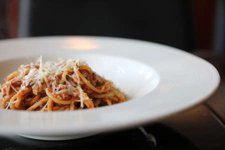 spaghetti Bolognese with minced beef and tomato sauce garnished with parmesan cheese and basilの写真素材