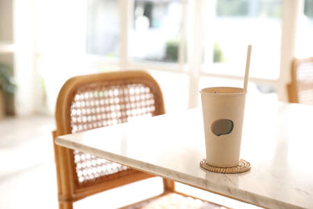 Iced coffee with paper glass in coffee shop backgroundの写真素材