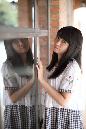 portrait of asian girl with white shirt and skirt looking in outdoor urban backgroundの写真素材