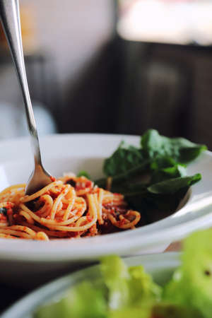 spaghetti Bolognese with italian sausage and tomato sauce with parmesan cheese and basilの写真素材