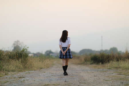beautiful asian japanese school girl uniform looking at park outdoorの写真素材