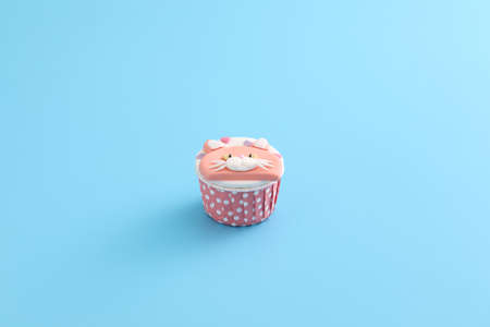 Cute cat cupcake isolated in blue backgroundの写真素材