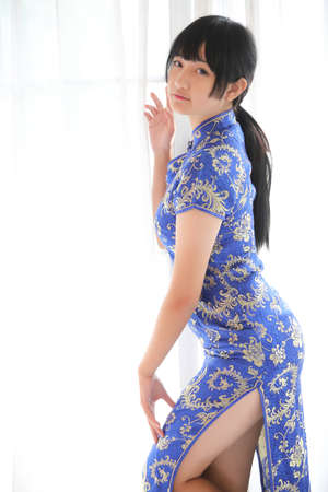 beauty woman wear blue cheongsam looking and smile in chinese new year