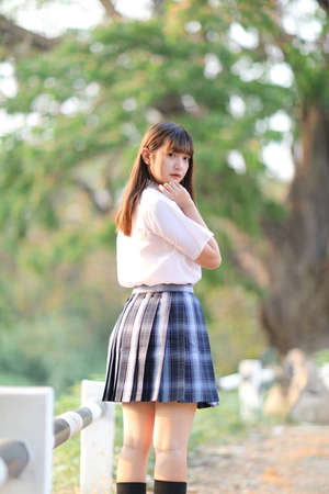 beautiful asian japanese school girl uniform looking at park outdoorの写真素材