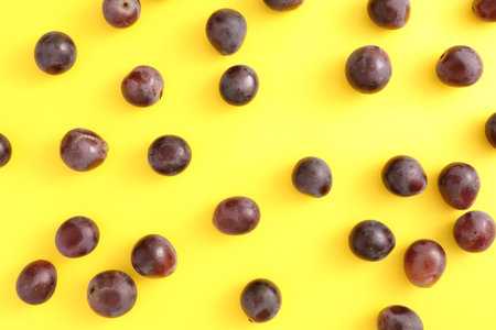 Red grapes isolated top view in yellow backgroundの写真素材