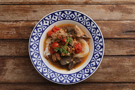 Local northern thai food Rice noodles with pork in spicy soup in wood backgroundの写真素材