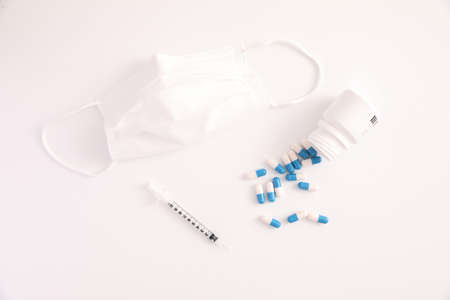 Syringe with pill and mask isolated in white backgroundの写真素材