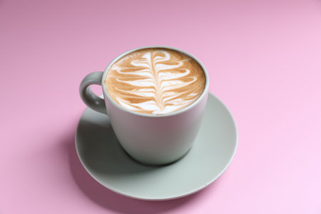 hot cappuccino with latte art isolated in pink backgroundの写真素材