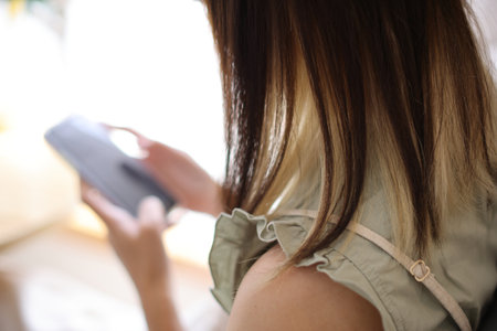 Woman hand using a smartphone for Stock exchange trading online in the coffee shop, business conceptの写真素材