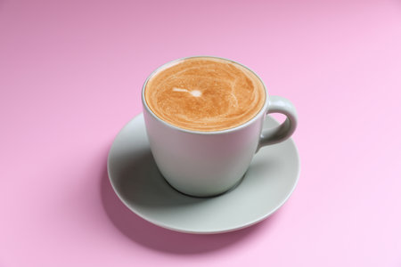 hot cappuccino with latte art isolated in pink background