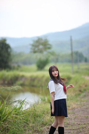 Japanese high school student looking on countryside backgroundの写真素材