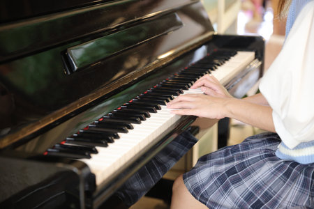 Close up of female hands playing a melody on piano