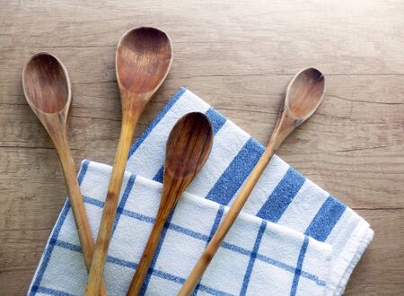 set of wooden cooking spoons and dishcloths on vintage kitchen tableの写真素材