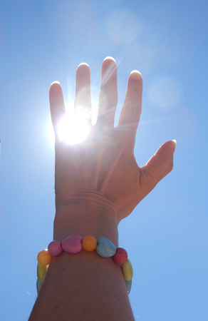 Close-up photography of hand catching the sun.の写真素材