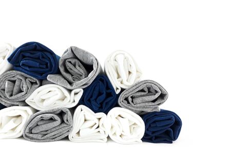 Pile of colours rolled t-shirts isolated on white background - close up.