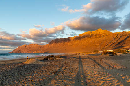 Famara beach and Risco de Famara mountains at sunset, Spainの写真素材