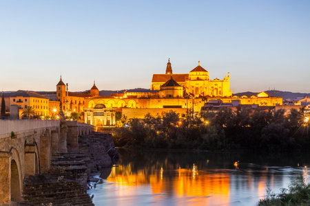 Classic view of Cordoba with Roman Bridge, Guadalquivir River and the Mezquita illuminated after sunsetの写真素材