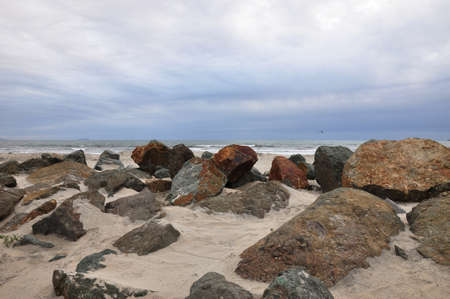 Large rocks dot the shoreline at a Coronado beach in San Diego, California.の写真素材